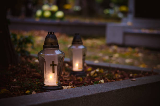 lanterns, candles and flowers during All Saints Day on grave on cemetery