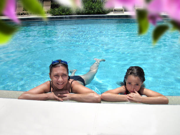 istock Mother and daughter summer fun in swimming pool 1344246541