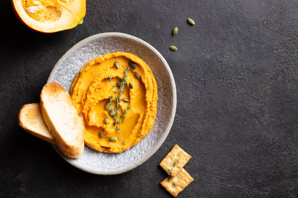 istock Pumpkin hummus decorated with greens and toasted bread 1344246710