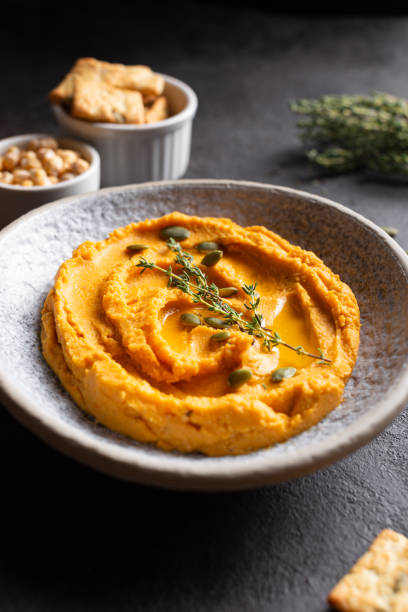 istock Bowl with pumpkin hummus, delicious appetizer decorated with greens and spices 1344246734