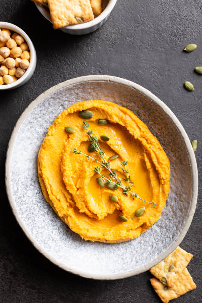 istock Bowl with pumpkin hummus, delicious appetizer decorated with greens and spices 1344246743