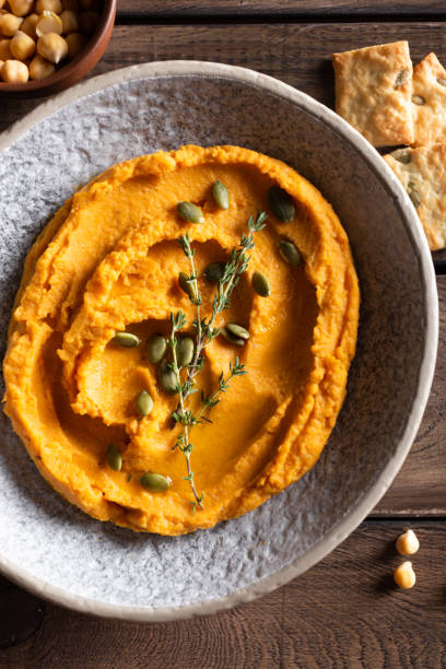 istock Bowl with pumpkin hummus, delicious appetizer decorated with greens and spices 1344246765