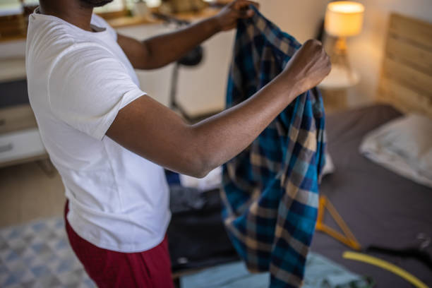 istock Young man packing suitcase and preparing for vacation 1344247445