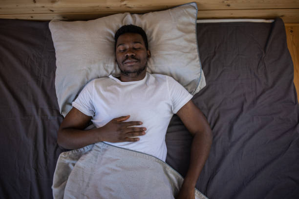 집에서 침대에서 자고있는 젊은 남자 - lying on back 이미지 뉴스 사진 이미지
