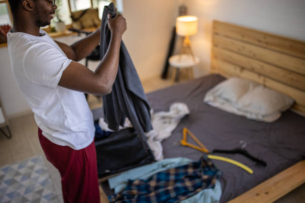 istock Young man packing suitcase and getting ready for vacation 1344247554