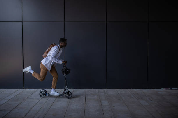 istock Young businessman riding push scooter on his way to home after work 1344248202