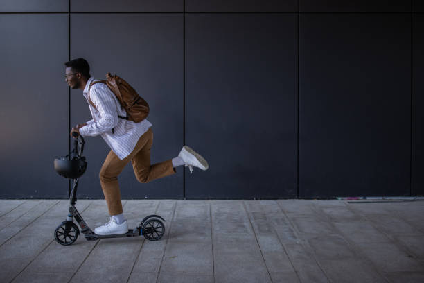 istock Young businessman riding push scooter and going home after work 1344249435