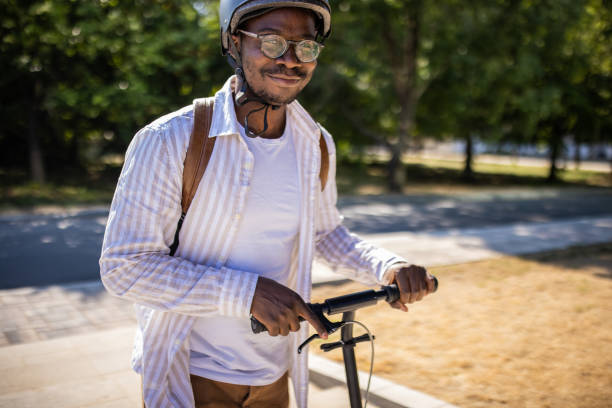 istock Young businessman going home after work with push scooter 1344249436