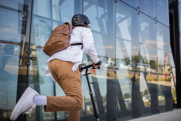 istock Young businessman in rush to get to work on time with push scooter 1344250171