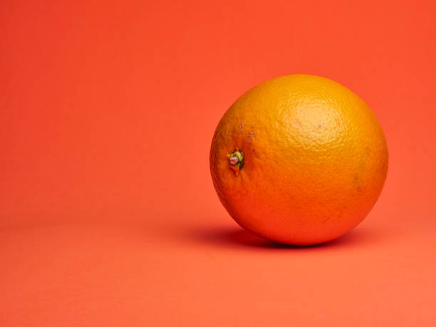 istock fresh orange on vibrant, monochromatic, orange background 1344250889