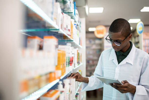 istock Young pharmacist checking the shelves with a digital tablet at the pharmacy 1344251445