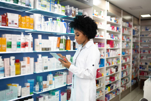 istock Young pharmacist checking the shelves with a digital tablet at the pharmacy 1344251513