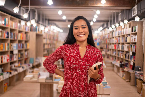 портрет современной женщины-библиотекаря азиатской национальности - bookstore стоковые фото и изображения