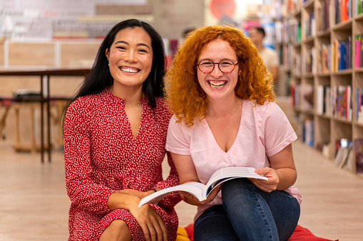 Portrait of confident and cheerful multiracial female University student, studying together at the library