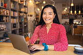 istock Modern young woman of Asian ethnicity, e-learning via laptop, at the modern and cozy cafeteria 1344252956