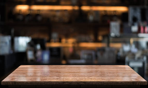 istock Empty wooden table top with lights bokeh on blur restaurant background 1344253331