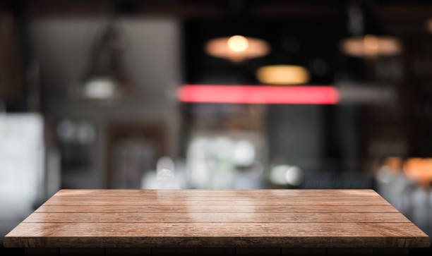 istock Empty wooden table top with lights bokeh on blur restaurant background 1344253334