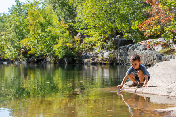 Boy Playing With Stick in Granite Quarry Pond