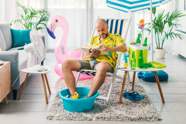 istock Man spending his vacations at home and reading a book 1344258471