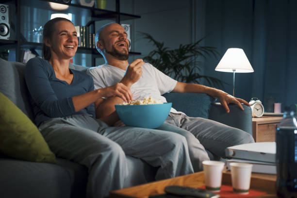 istock Cheerful couple watching TV together 1344261837