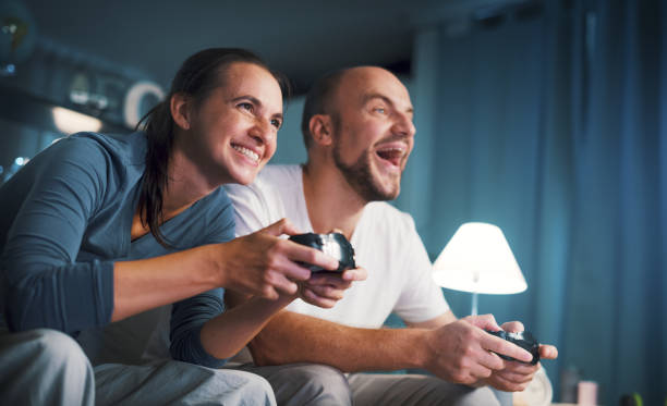 istock Happy couple playing video games at home 1344263639