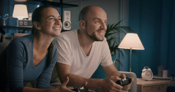 istock Happy couple playing video games at home 1344263885