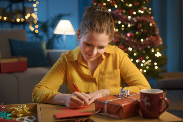 istock Happy woman writing a Christmas card 1344267649