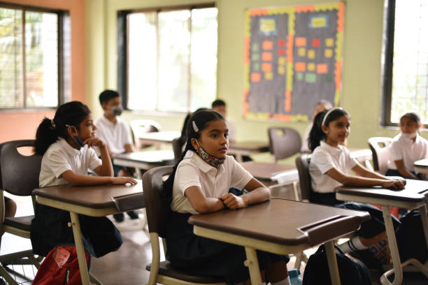 istock School children sitting in classroom with mask down 1344268851
