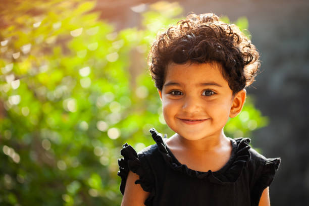 a small girl smiling while seeing towards camera - criança de 1 a 2 anos imagens e fotografias de stock