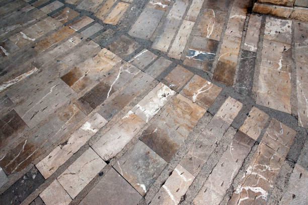 Rough hewn stone walkways create a pattern in Alcudia old town, Majorca, Balearic Islands, Spain Carved and etched stone walkways create patterns in the alleyways and lanes within the fortress walls surrounding the ancient old town with its preserved and restored medieval and historic architecture of Alcudia, Majorca, Balearic Islands, Spain roughhewn stock pictures, royalty-free photos & images