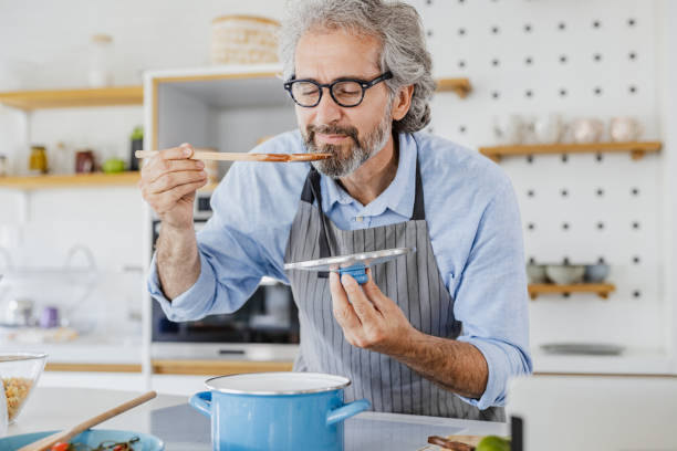 istock Senior man preparing food at home 1344270617