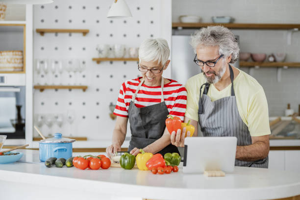 istock Senior couple cooking together at home 1344270771