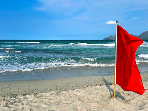A red flag on the rocks in Carrizalillo beach in Puerto Escondido, Mexico