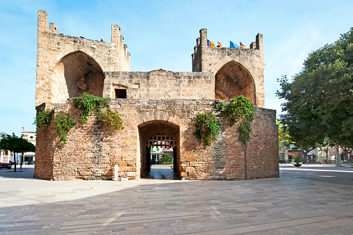 Fortified stone gateway of the fortress walls surrounding the ancient town of the preserved and restored medieval and historic architecture of Alcudia, Majorca, Balearic Islands, Spain