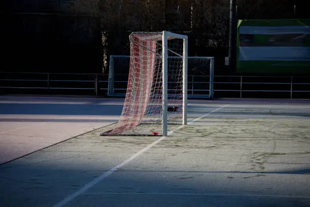 Soccer goal in eraly winter morning with frost and raising sun