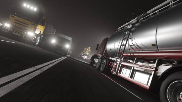 low angle view of various commercial vehicles moving on the road at night - truck motion road cement truck imagens e fotografias de stock