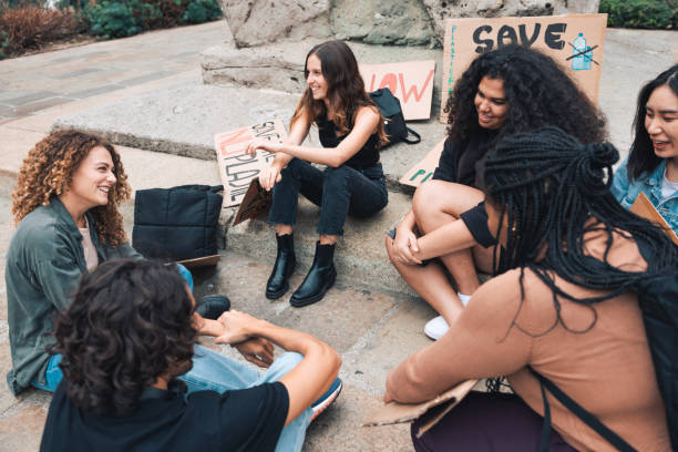 istock Group of young activists sitting in circle during a strike for saving environment 1344275037