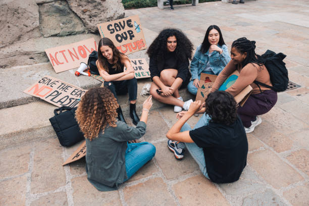 istock Group of young activists sitting in circle during a strike for saving environment 1344275233