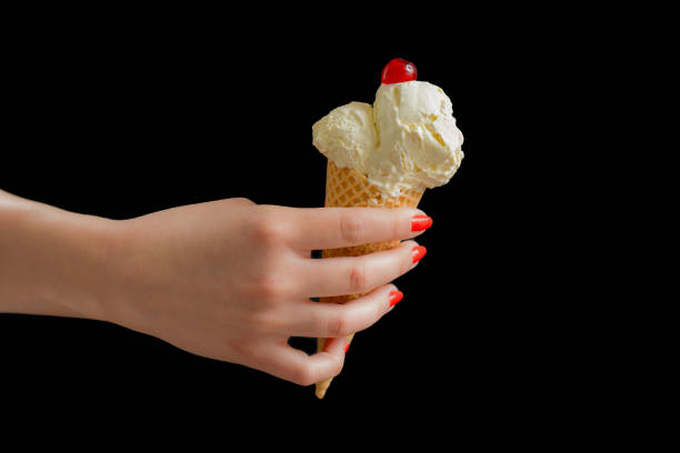 Girl'S Hand Holding Ice Cream In Waffle Cone Decorated With Pills a hot day outside. close up, no face