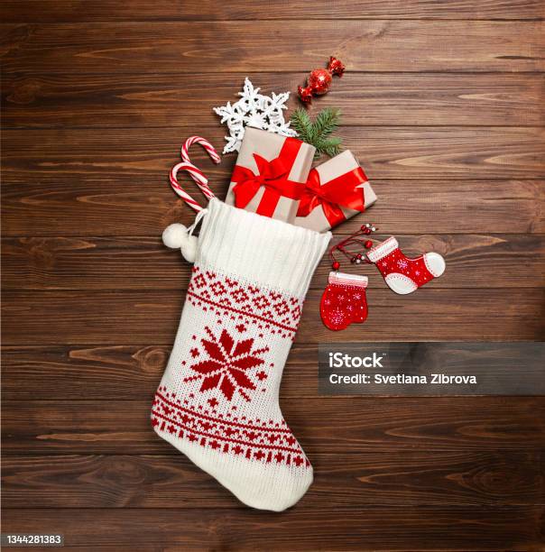 Christmas Stocking White With Gifts Sweets Snowflake On A Wooden Background View From Above Stock Photo - Download Image Now