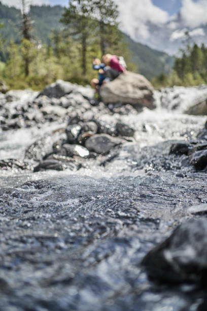 istock Friends relax on rock formation near flowing river 1344282461