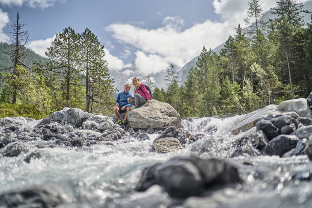 istock Friends relax on rock formation near flowing river 1344282462