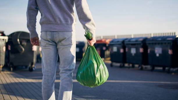 mann mit müllsack - green garbage bag stock-fotos und bilder