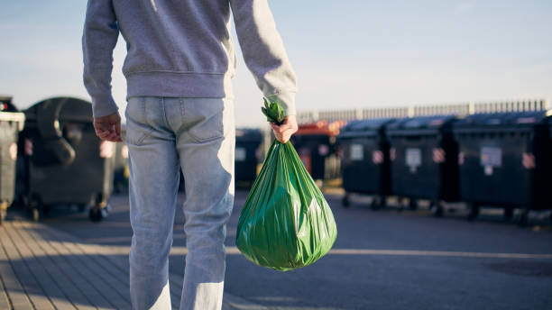 человек несет мешок для мусора - green garbage bag стоковые фото и изображения