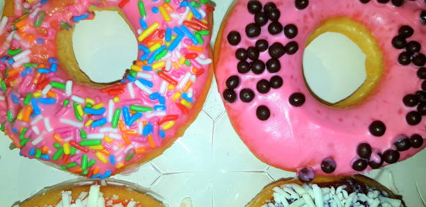 istock Delicious assorted donuts with chocolate frosted, pink glazed and sprinkles donuts different type of donuts 1344285077