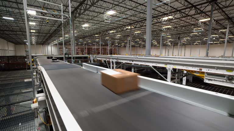 Handheld Shot Walking Alongside Package Conveyor Belt in Fulfillment Center