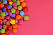 Round multicolored candy on a pink background frame stock images