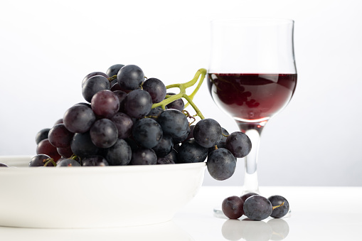 Wine in glass and grapes in a bowl