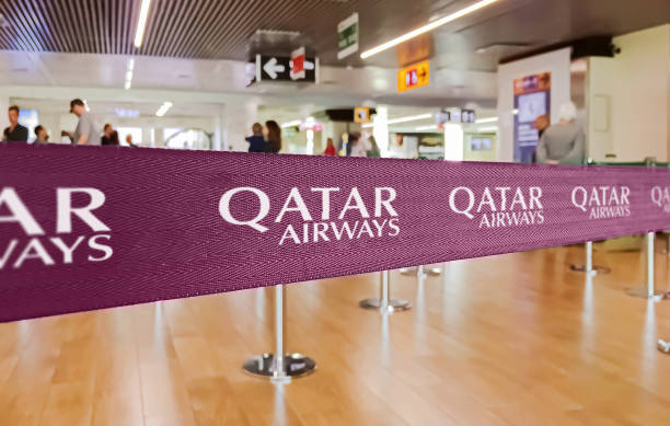 purple ribbon barrier with the qatar airways airline logo - qatar airways stok fotoğraflar ve resimler