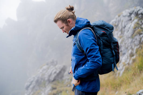 istock Male hiker relaxes on grassy mountain ridge 1344298137